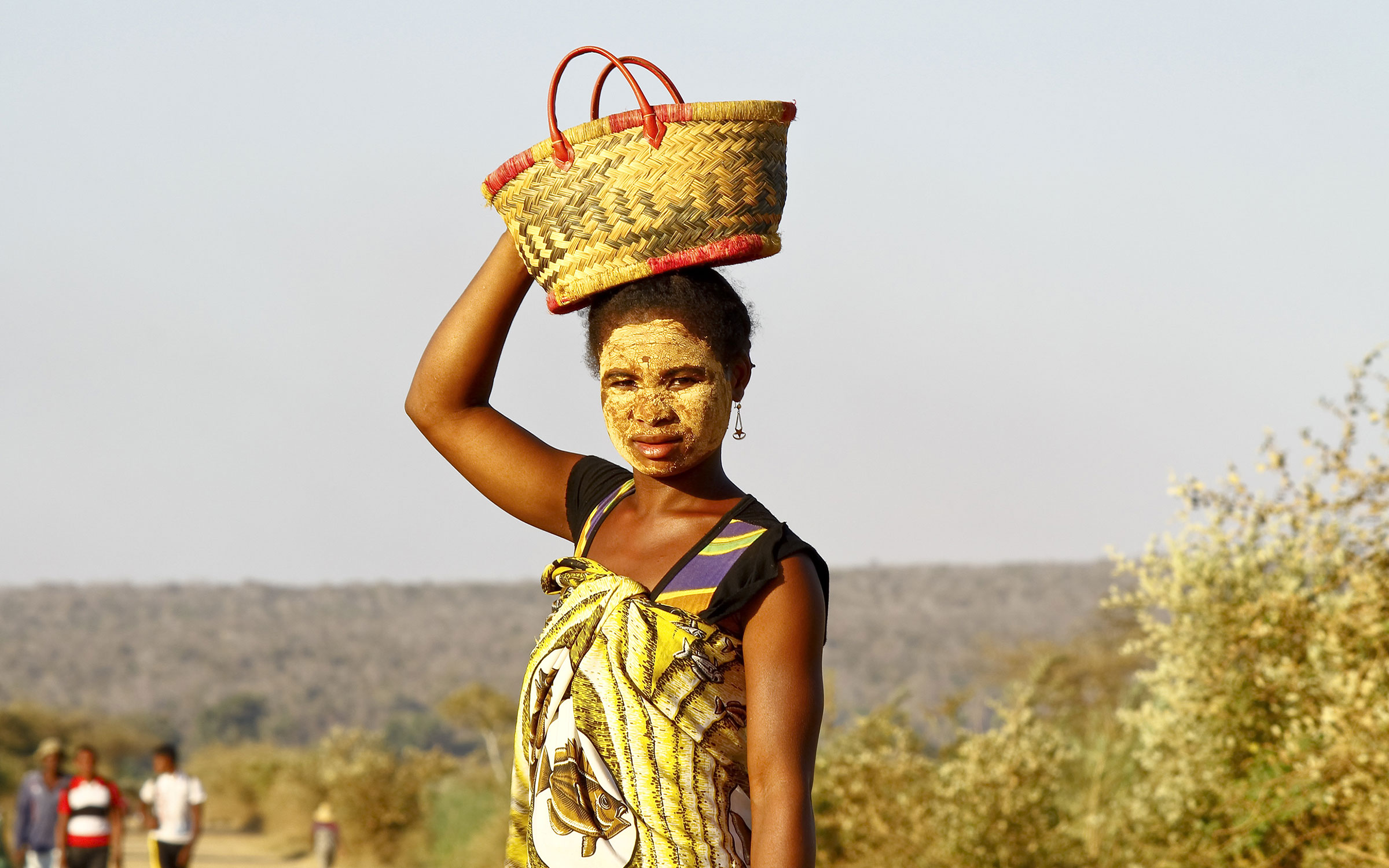 Lokal stammekvinne med tradisjonell ansiktsmaske og flettet kurv