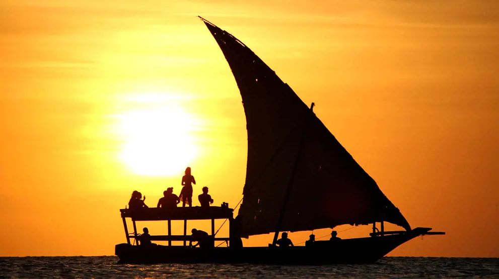 Dhow-båt i flott solnedgang langs Zanzibars kyst