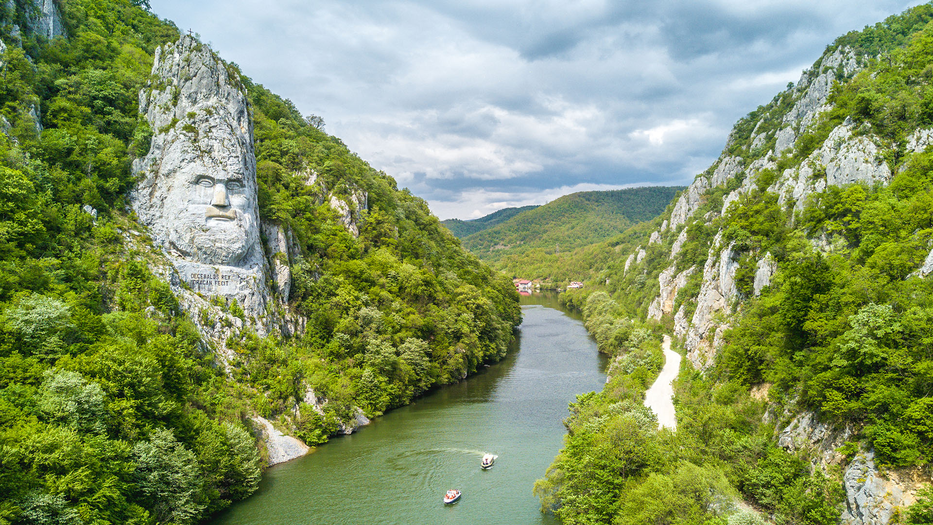 Dere seiler gjennom Jernporten og forbi det ikoniske Decebalus-relieffet, hugget inn i fjellsiden