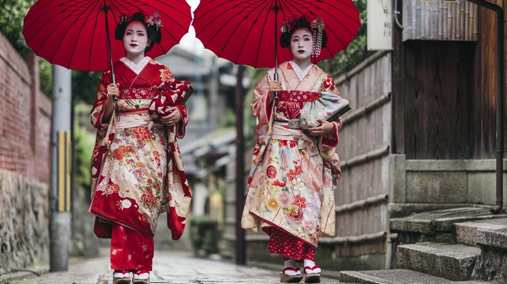 To geishaer spaserer nedover Gions gater i Kyoto 