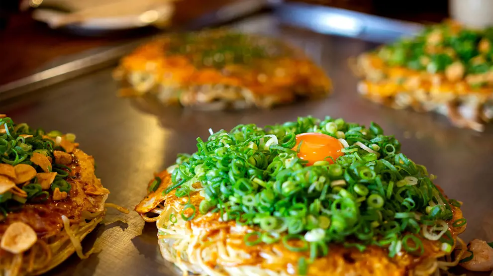 Du skal prøve den lokale spesialitet okonomiyaki, når du reiser til Hiroshima