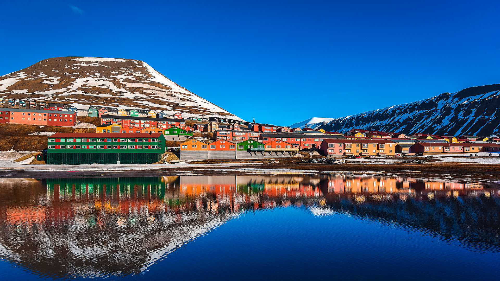 Longyearbyen ligger på kanten av villmarken, med fargerik sjarm og utsikt til snøkledde tinder